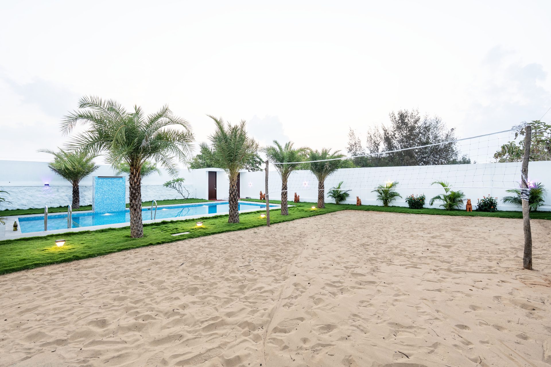 Sand volleyball court and pool at dusk
